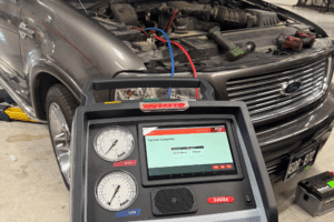 Car a/c diagnostics, auto repair in Thornton, CO at Alternate Auto Care. Image of professional air conditioning service equipment performing an A/C system evacuation and recharge on a Ford SUV.