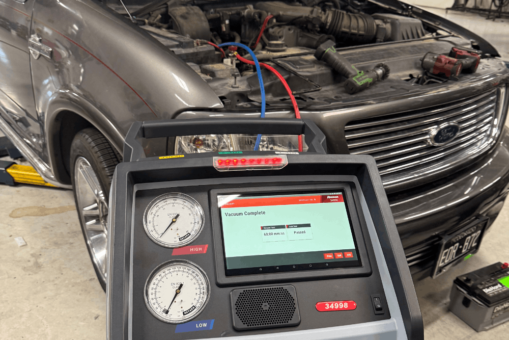 Car a/c diagnostics, auto repair in Thornton, CO at Alternate Auto Care. Image of professional air conditioning service equipment performing an A/C system evacuation and recharge on a Ford SUV.